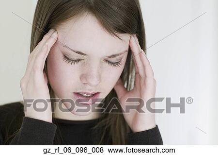 Studio shot of young woman rubbing temples View Large Photo Image Stock Photo - Studio shot of young woman rubbing temples. Fotosearch