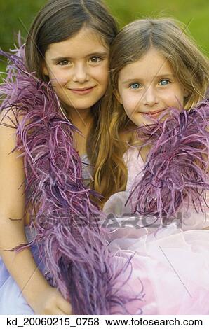Two young girls wearing feather boa and smiling View Large Photo Image Stock Photo - Two young girls wearing feather boa and smiling. Fotosearch
