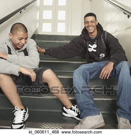 Two young men laughing on stairs at school View Large Photo Image Stock Photo - Two young men laughing on stairs at school. Fotosearch