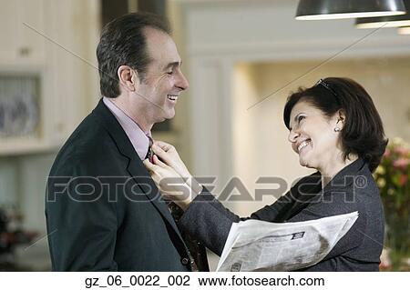 Woman adjusting man's tie and smiling View Large Photo Image Stock Image - Woman adjusting man's tie and smiling. Fotosearch