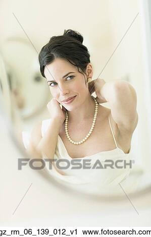 Woman in fancy clothing putting on pearl necklace View Large Photo Image Stock Image - Woman in fancy clothing putting on pearl necklace. Fotosearch
