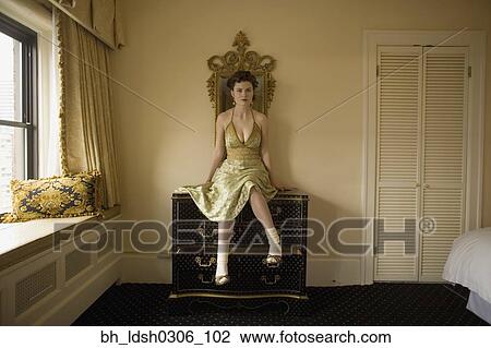 Woman in fancy dress sitting on dresser View Large Photo Image Stock Image - Woman in fancy dress sitting on dresser. Fotosearch