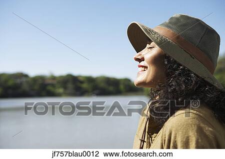 Stock Image - Woman smiling with sun on her face. Fotosearch