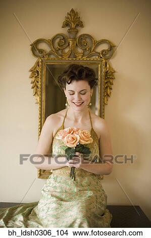 Woman wearing fancy dress and holding flowers View Large Photo Image Picture - Woman wearing fancy dress and holding flowers. Fotosearch