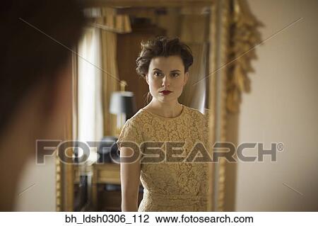 Woman wearing fancy dress looking in mirror View Large Photo Image Stock Image - Woman wearing fancy dress looking in mirror. Fotosearch