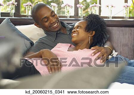 Stock Image - Young African couple looking at each other and smiling. Fotosearch