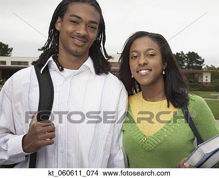 Picture - Young African couple smiling with school books. Fotosearch