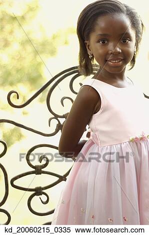 Young African girl smiling next to gate View Large Photo Image Stock Photography - Young African girl smiling next to gate. Fotosearch