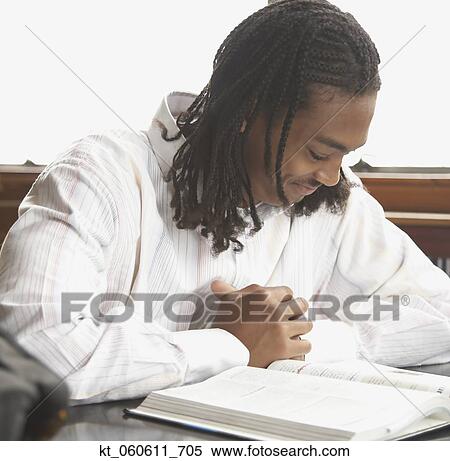Young African man reading text book View Large Photo Image Stock Photography - Young African man reading text book. Fotosearch