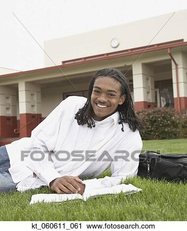 Stock Image - Young African man smiling on school campus. Fotosearch