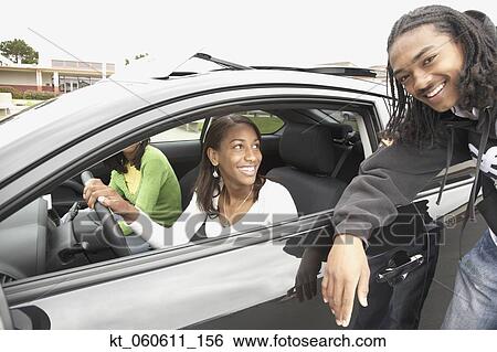 Stock Photograph - Young African man talking to friends in car. Fotosearch