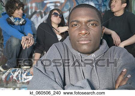 Young African man with friends next to graffitied wall View Large Photo Image Stock Image - Young African man with friends next to graffitied wall. Fotosearch