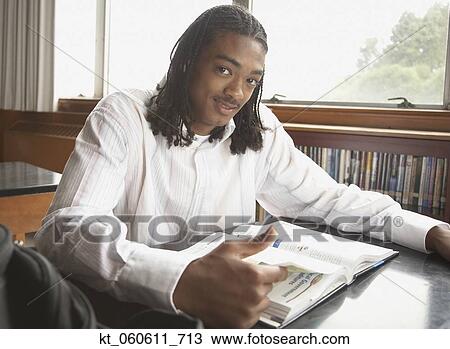 Young African man with text book View Large Photo Image Stock Image - Young African man with text book. Fotosearch