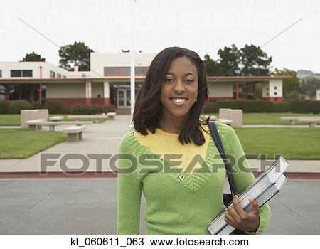 Stock Image - Young African woman smiling on school campus. Fotosearch