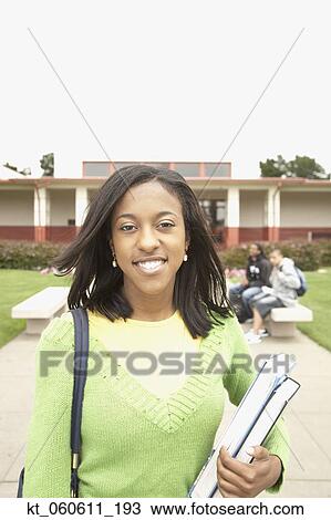 Stock Image - Young African woman smiling on school campus. Fotosearch