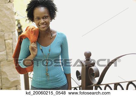 Young African woman with jacket over shoulder smiling View Large Photo Image Stock Photo - Young African woman with jacket over shoulder smiling. Fotosearch