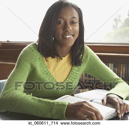 Young African woman with text book View Large Photo Image Picture - Young African woman with text book. Fotosearch
