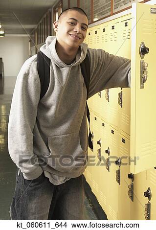 Picture - Young Asian man next to school lockers. Fotosearch