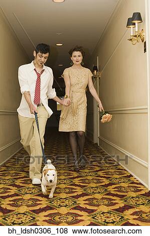 Young coupled dressed up walking down hotel hallway with dog View Large Photo Image Stock Photo - Young coupled dressed up walking down hotel hallway with dog. Fotosearch