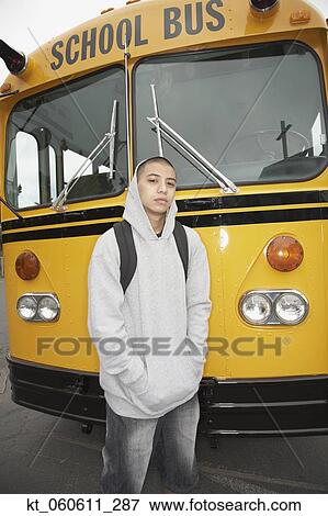 Stock Photo - Young man with backpack next to school bus. Fotosearch