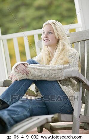 Young woman in sweater sitting on porch View Large Photo Image Stock Image - Young woman in sweater sitting on porch. Fotosearch