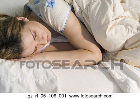 Stock Image - Young woman sleeping in bed. Fotosearch