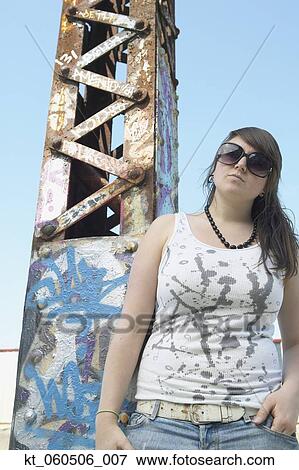 Young woman standing next to graffitied metal tower View Large Photo Image Stock Photo - Young woman standing next to graffitied metal tower. Fotosearch