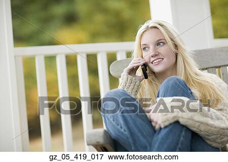 Young woman using cell phone outdoors View Large Photo Image Stock Photo - Young woman using cell phone outdoors. Fotosearch