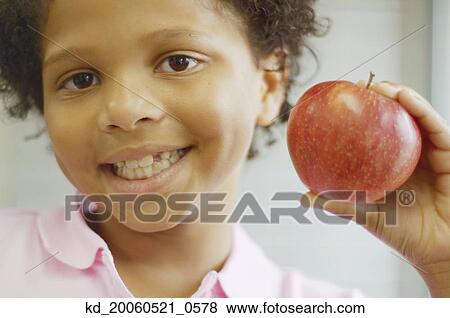 African boy holding apple and smiling View Large Photo Image Stock Photo - African boy holding apple and smiling. Fotosearch