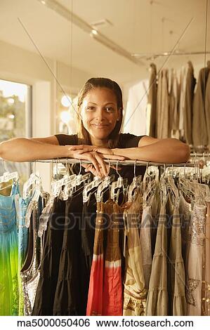 African woman leaning on rack at clothing store View Large Photo Image Stock Photograph - African woman leaning on rack at clothing store. Fotosearch