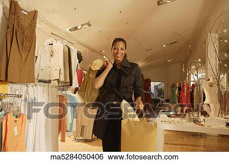 Stock Photograph - African woman with shopping bags at boutique. Fotosearch
