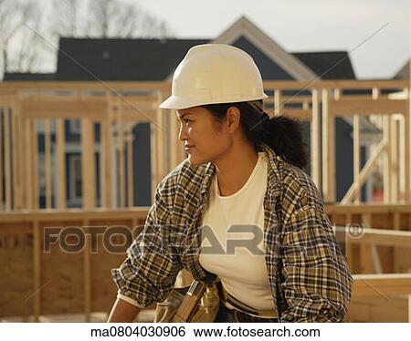 Stock Photograph - Asian female construction worker at construction site. Fotosearch