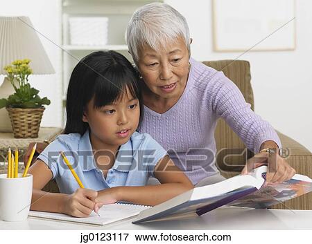 Stock Photo - Asian grandmother and granddaughter doing homework. Fotosearch