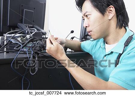 Asian male computer service technician with bundle of wires View Large Photo Image Picture - Asian male computer service technician with bundle of wires. Fotosearch