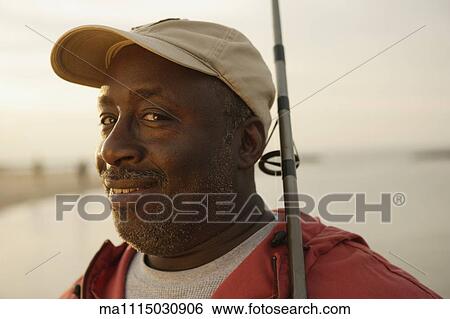Close up of African man holding fishing pole View Large Photo Image Stock Photograph - Close up of African man holding fishing pole. Fotosearch
