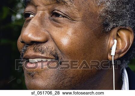 Close up of senior African man with earbud View Large Photo Image Stock Photo - Close up of senior African man with earbud. Fotosearch