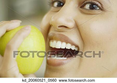 Close up of woman about to bite into an apple View Large Photo Image Stock Image - Close up of woman about to bite into an apple. Fotosearch