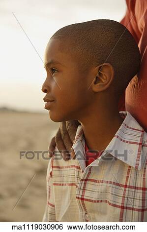Stock Photograph - Close up of young African boy at beach. Fotosearch