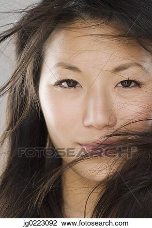 Close up of young Asian woman with hair in face View Large Photo Image Stock Image - Close up of young Asian woman with hair in face. Fotosearch