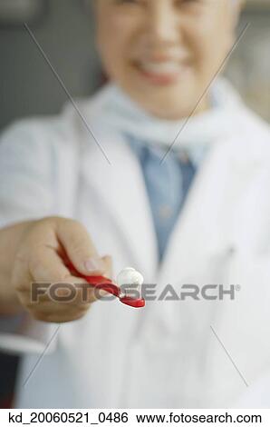 Female dentist holding out toothbrush with toothpaste View Large Photo Image Stock Photograph - Female dentist holding out toothbrush with toothpaste. Fotosearch