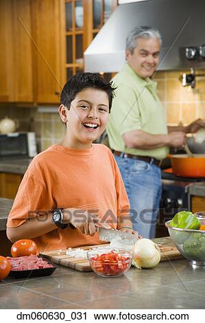 Hispanic father and son cooking and chopping vegetables in kitchen View Large Photo Image Stock Image - Hispanic father and son cooking and chopping vegetables in kitchen. Fotosearch