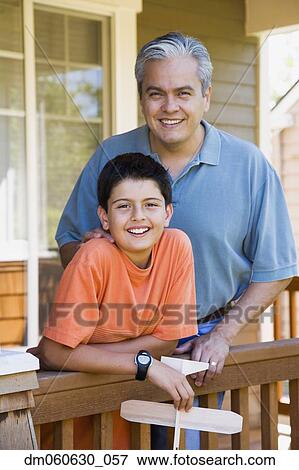 Hispanic father and son holding model airplane on porch View Large Photo Image Stock Photo - Hispanic father and son holding model airplane on porch. Fotosearch