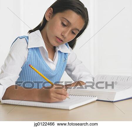 Hispanic girl doing homework at table View Large Photo Image Stock Photograph - Hispanic girl doing homework at table. Fotosearch