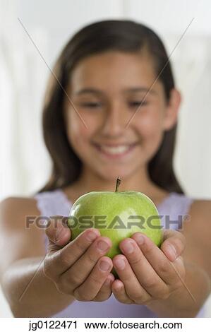 Hispanic girl holding apple in outstretched hands View Large Photo Image Stock Image - Hispanic girl holding apple in outstretched hands. Fotosearch