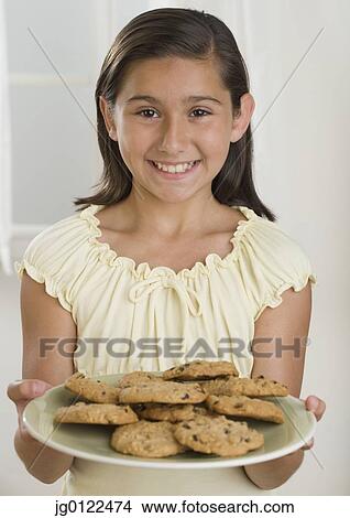 Hispanic girl holding plate of cookies View Large Photo Image Picture - Hispanic girl holding plate of cookies. Fotosearch
