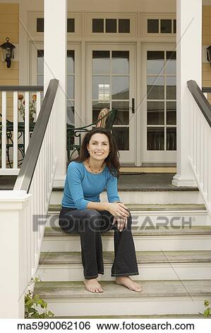 Hispanic woman sitting on porch stairs smiling View Large Photo Image Stock Photograph - Hispanic woman sitting on porch stairs smiling. Fotosearch