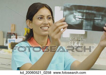 Indian female dental assistant looking at x-rays View Large Photo Image Stock Photo - Indian female dental assistant looking at x-rays. Fotosearch