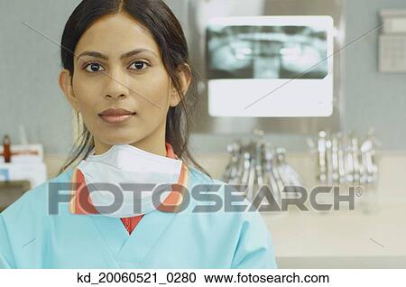 Stock Image - Indian female dental assistant next to x-rays. Fotosearch