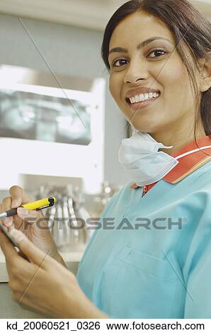 Indian female dental assistant writing on chart View Large Photo Image Stock Photograph - Indian female dental assistant writing on chart. Fotosearch