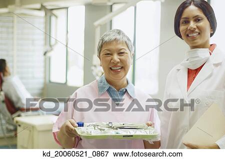 Indian female dentist and senior Asian female dental assistant smiling View Large Photo Image Stock Photo - Indian female dentist and senior Asian female dental assistant smiling. Fotosearch